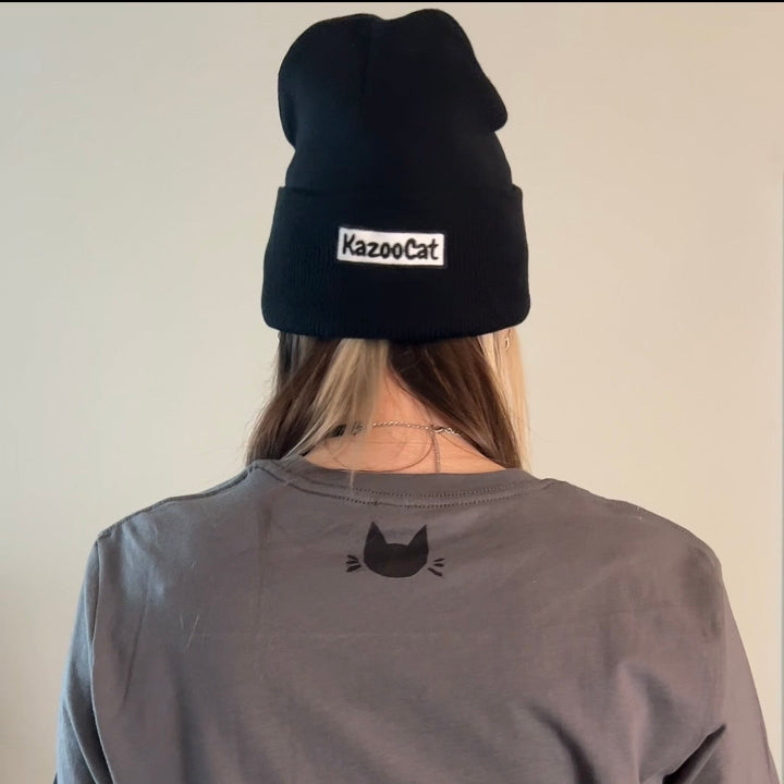 Person wearing a black beanie with 'KazooCat' logo and a gray shirt with a cat icon.