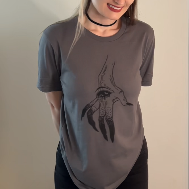 Person wearing a gray t-shirt with a black graphic design against a plain background
