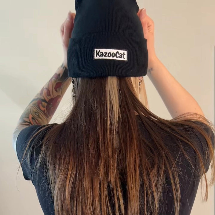 Person wearing a black beanie with 'KazooCat' logo.